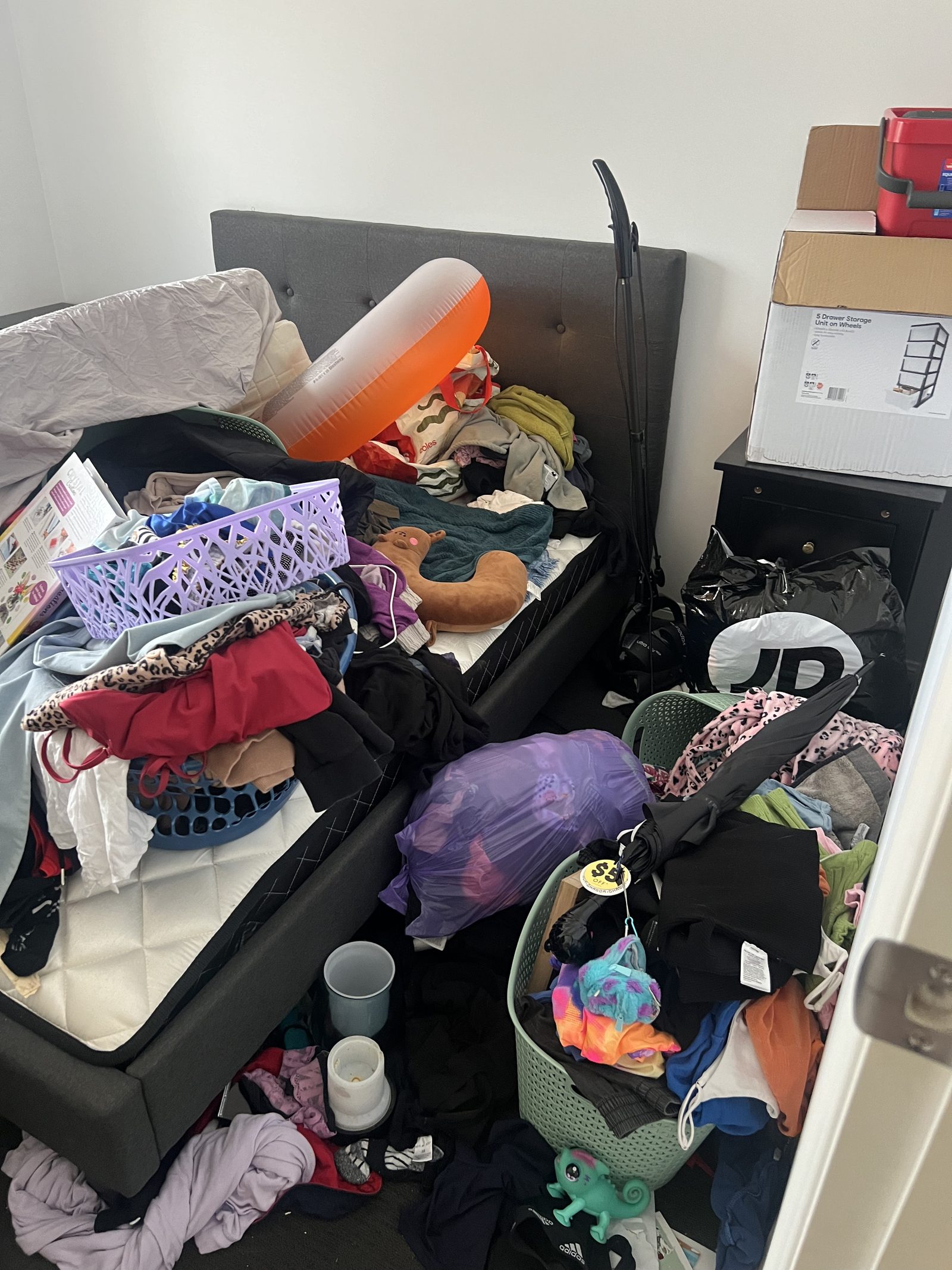 A bedroom piled with laundry and clutter before a Care for a Clean session