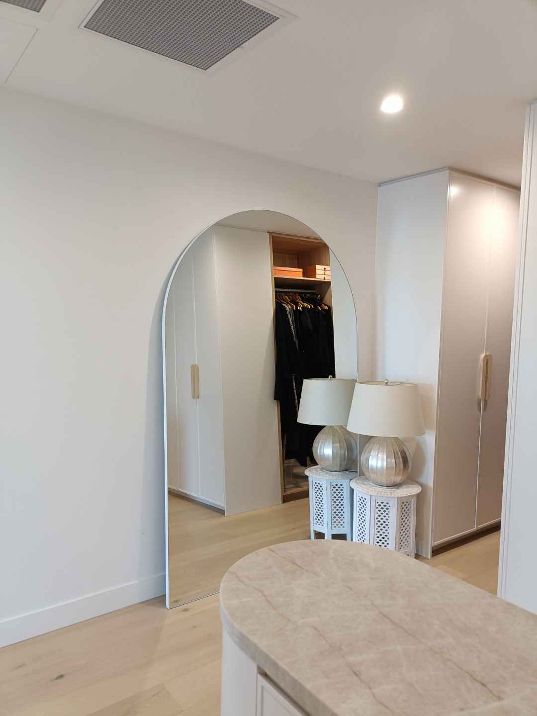 An arched bedroom mirror and dressing area cleaned streak-free