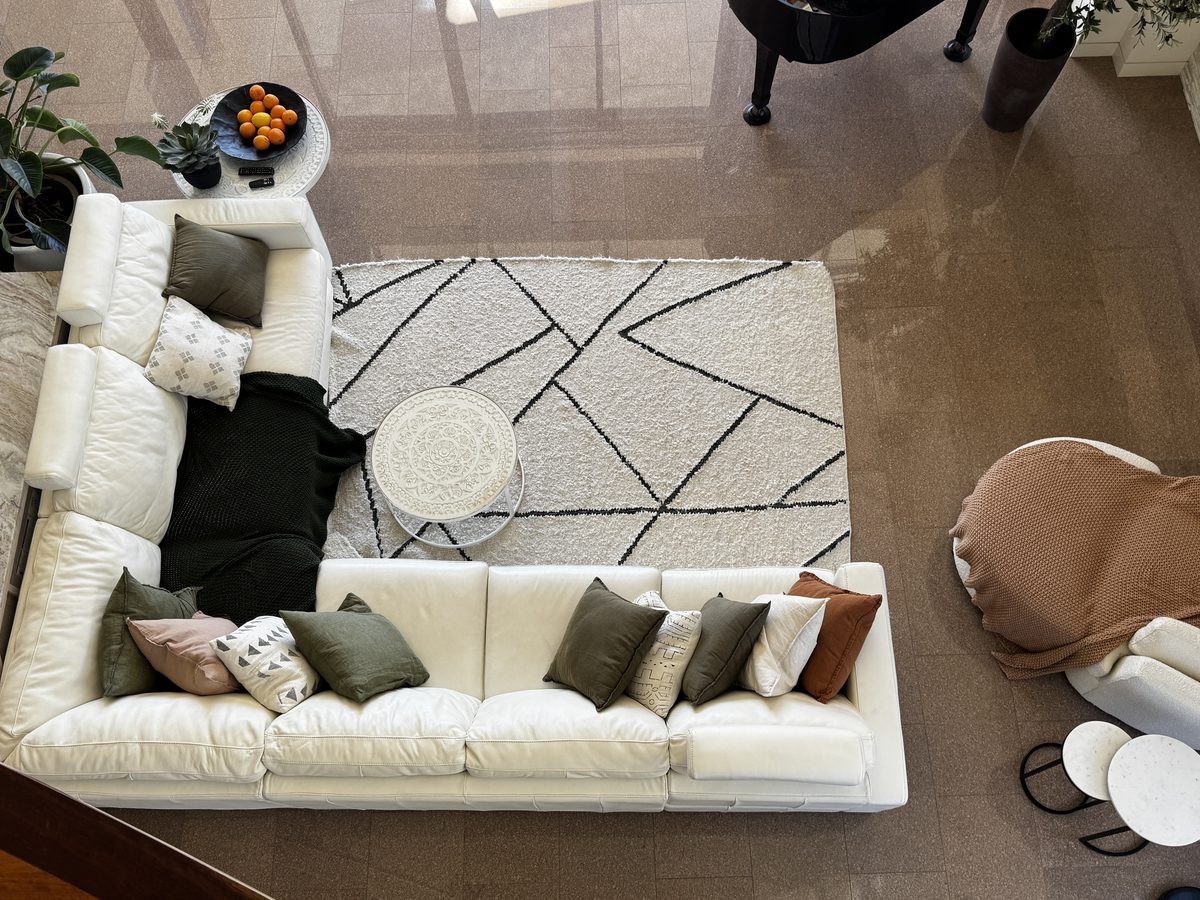 An open-plan living room viewed from above, styled and kept immaculate as part of ongoing home management