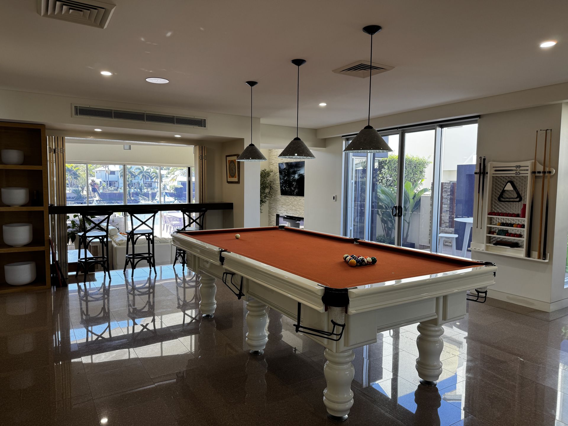 A games room with the pool table and floors cleaned throughout